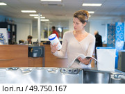beautiful girl trying to pick product from catalogue. Стоковое фото, агентство Ingram Publishing / Фотобанк Лори