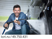 man washing his car under high pressure water outdoors. Стоковое фото, агентство Ingram Publishing / Фотобанк Лори