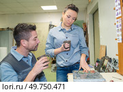 workers having coffee while examining marble commemorative plaque. Стоковое фото, агентство Ingram Publishing / Фотобанк Лори