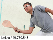 young squash player holding racket in four-walled court. Стоковое фото, агентство Ingram Publishing / Фотобанк Лори