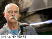 portrait of a senior man with a blowtorch. Стоковое фото, агентство Ingram Publishing / Фотобанк Лори