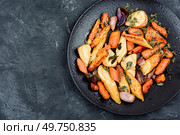 Vegan garnish of baked parsnip root, red onions, carrots and garlic. Roasted root vegetables. Space for text.. Roasted parsnip root and carrots. Стоковое фото, агентство Ingram Publishing / Фотобанк Лори