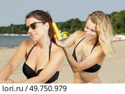 woman on sun lounger applying sunblock. Стоковое фото, агентство Ingram Publishing / Фотобанк Лори