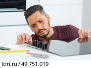 man fitting the hob on the table top. Стоковое фото, агентство Ingram Publishing / Фотобанк Лори