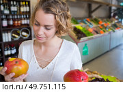 Woman holding mangoes in greengrocers. Стоковое фото, агентство Ingram Publishing / Фотобанк Лори
