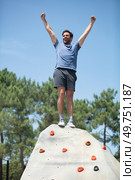 rock-climber stands triumphant at the top of artificial-wall. Стоковое фото, агентство Ingram Publishing / Фотобанк Лори