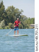 man enjoying a ride on the lake with paddleboard. Стоковое фото, агентство Ingram Publishing / Фотобанк Лори