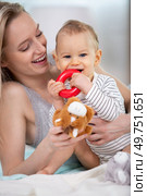 a mother playing with her baby in the bedroom. Стоковое фото, агентство Ingram Publishing / Фотобанк Лори