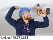 young man is drilling the ceiling. Стоковое фото, агентство Ingram Publishing / Фотобанк Лори
