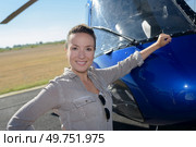 beautiful woman in pilot overalls resting her arm against helicopter. Стоковое фото, агентство Ingram Publishing / Фотобанк Лори