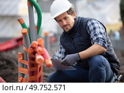 workman inspecting pipe conduits on site. Стоковое фото, агентство Ingram Publishing / Фотобанк Лори