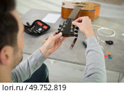 man repairing acoustic guitar in his workshop. Стоковое фото, агентство Ingram Publishing / Фотобанк Лори