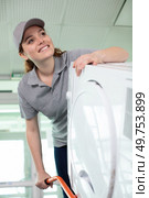 pleasant upbeat charming deliverywoman holding washing machine. Стоковое фото, агентство Ingram Publishing / Фотобанк Лори