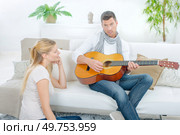 Trying to impress his girlfriend by playing guitar. Стоковое фото, агентство Ingram Publishing / Фотобанк Лори
