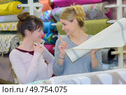 smiling young customer buying fabric. Стоковое фото, агентство Ingram Publishing / Фотобанк Лори