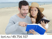 couple looking at a navigation book and sea charts. Стоковое фото, агентство Ingram Publishing / Фотобанк Лори