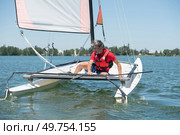 a man leaning across catamaran. Стоковое фото, агентство Ingram Publishing / Фотобанк Лори