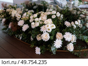 The presidium of the newlyweds in the banquet hall of the restaurant is decorated with candles and green plants, wisteria hangs from the ceiling. Стоковое фото, агентство Ingram Publishing / Фотобанк Лори