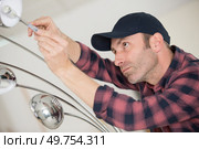 handyman fixate a lamp on the ceiling. Стоковое фото, агентство Ingram Publishing / Фотобанк Лори