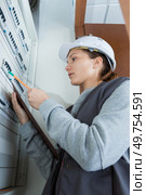 female electrician checking distribution fuseboard. Стоковое фото, агентство Ingram Publishing / Фотобанк Лори
