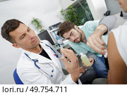 doctor and nurse doing injured man tetanus toxoid injection. Стоковое фото, агентство Ingram Publishing / Фотобанк Лори