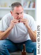 Middle aged man rolling a cigarette. Стоковое фото, агентство Ingram Publishing / Фотобанк Лори