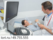doctor showing baby ultrasound image on computer to pregnant woman. Стоковое фото, агентство Ingram Publishing / Фотобанк Лори