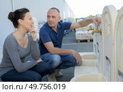 hardware store salesman assisting customers in buying garden stones. Стоковое фото, агентство Ingram Publishing / Фотобанк Лори