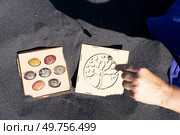 Hand holding pendulum with chakra healing crystals. Witchcraft, herbal medicine and healing, Magic healing Rock for Reiki Crystal Ritual, Witchcraft, spiritual esoteric practice. Healing crystals on black sand background. Стоковое фото, агентство Ingram Publishing / Фотобанк Лори
