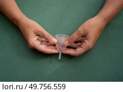 Hands holding menstrual cup over violet background, eco friendly and zero waste solution. Menstrual cap over violet background. Стоковое фото, агентство Ingram Publishing / Фотобанк Лори