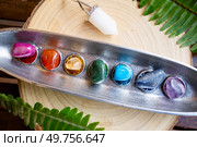 seven chakras stones over wooden background, energy healing concept. seven chakras stones, energy healing concept. Стоковое фото, агентство Ingram Publishing / Фотобанк Лори