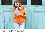 Frontal portrait of a modern casual latin woman working with tablet standing in the city. Woman working with tablet standing in the city. Стоковое фото, агентство Ingram Publishing / Фотобанк Лори