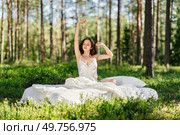 Woman sleeps on a mattress in the summer forest. Girl wakes up in a summer forest. Стоковое фото, агентство Ingram Publishing / Фотобанк Лори