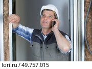 professional builder solving matters by phone during construction works indoors. Стоковое фото, агентство Ingram Publishing / Фотобанк Лори