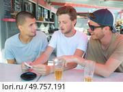 three men drinking beer at terrace bar. Стоковое фото, агентство Ingram Publishing / Фотобанк Лори