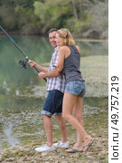 young couple angling standing on river shore. Стоковое фото, агентство Ingram Publishing / Фотобанк Лори