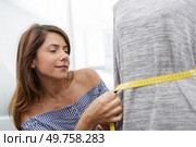 beautiful young woman in measuring dummy with tape. Стоковое фото, агентство Ingram Publishing / Фотобанк Лори