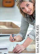 portrait of woman fitting laminated floor boards. Стоковое фото, агентство Ingram Publishing / Фотобанк Лори