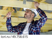 man hammers a wooden framed house. Стоковое фото, агентство Ingram Publishing / Фотобанк Лори