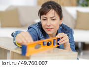 handywoman holding a level ruler. Стоковое фото, агентство Ingram Publishing / Фотобанк Лори