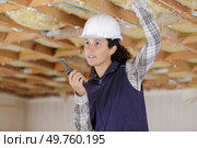 a woman uses a walkie inside construction. Стоковое фото, агентство Ingram Publishing / Фотобанк Лори