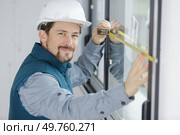 man measuring window prior to installation of roller shutter. Стоковое фото, агентство Ingram Publishing / Фотобанк Лори