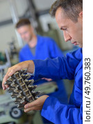 machinist holding a machine part. Стоковое фото, агентство Ingram Publishing / Фотобанк Лори