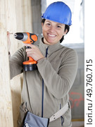 female construction worker having driller tool drilling wall. Стоковое фото, агентство Ingram Publishing / Фотобанк Лори