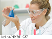 positive minded woman smiling while looking at a test tube. Стоковое фото, агентство Ingram Publishing / Фотобанк Лори