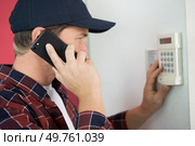 man installing a programmable room thermostat. Стоковое фото, агентство Ingram Publishing / Фотобанк Лори