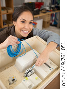 woman fixing electrics fuse box. Стоковое фото, агентство Ingram Publishing / Фотобанк Лори