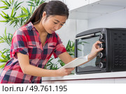 woman with new cooker and instruction manual. Стоковое фото, агентство Ingram Publishing / Фотобанк Лори