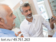 optician showing the patient a pair of eyeglasses. Стоковое фото, агентство Ingram Publishing / Фотобанк Лори