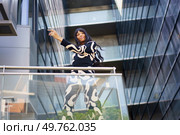 Low angle view photo of a female caucasian dancer performing choreography from urban stairs. Dancer performing choreography from urban stairs. Стоковое фото, агентство Ingram Publishing / Фотобанк Лори